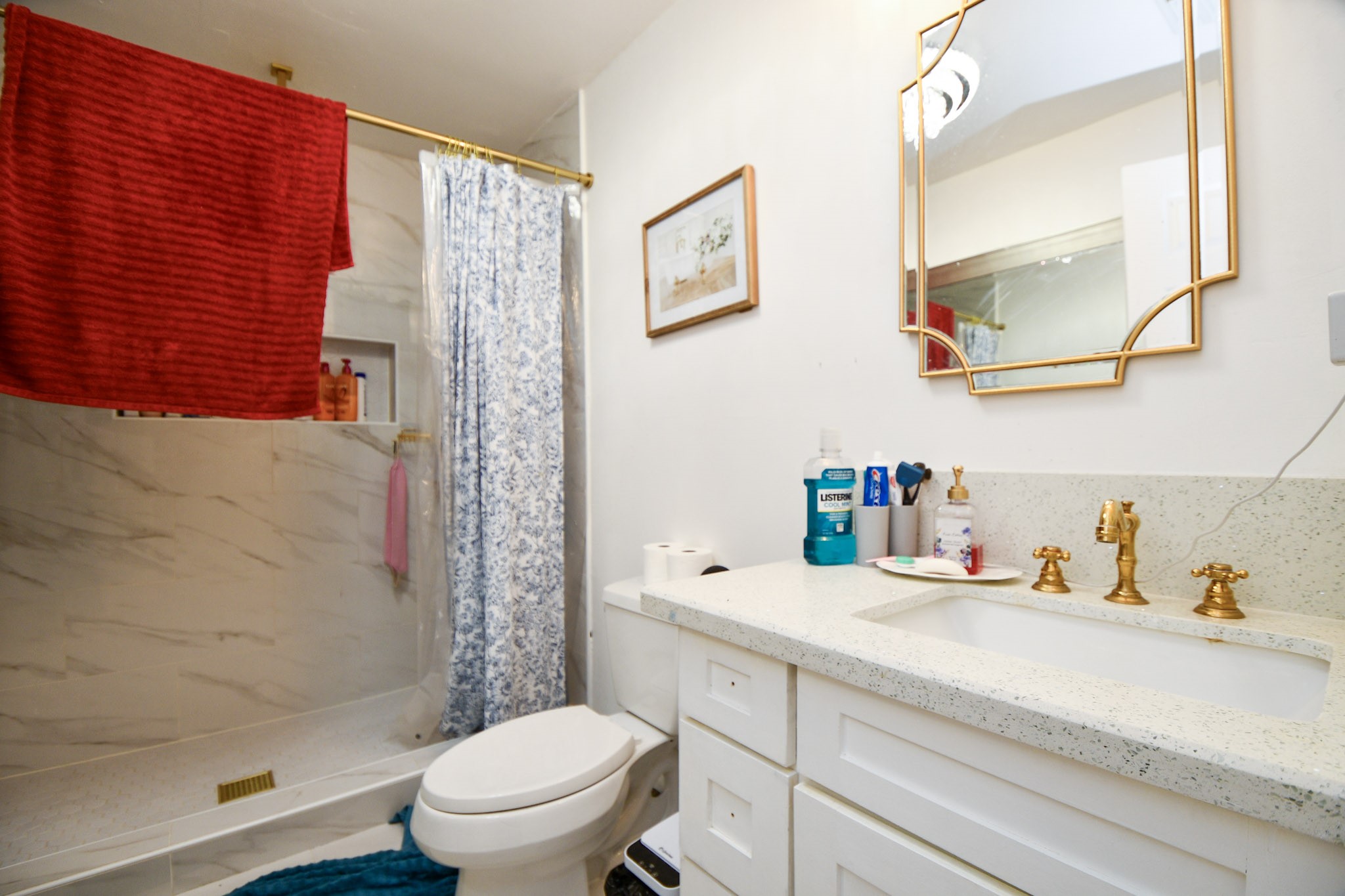 16005 Old Richmond Road Sugar Land, TX 77498 - Photo 33 of 46 a bathroom with a sink a toilet and shower curtain