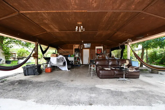 a view of a patio with table and chairs under an umbrella