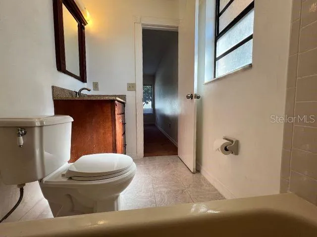 a bathroom with a toilet and a mirror