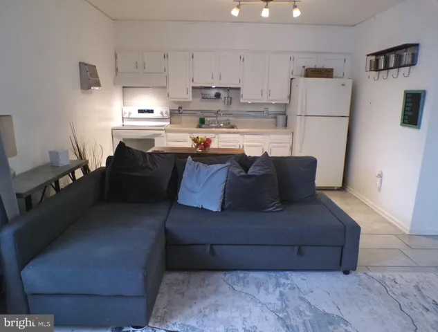 a living room with a couch and a refrigerator