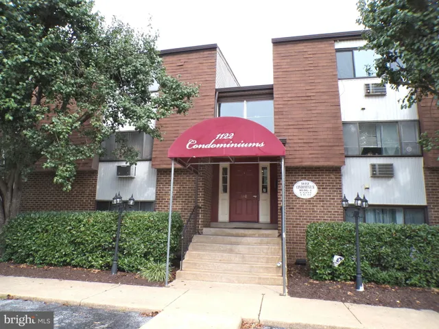 a front view of a building with a garden