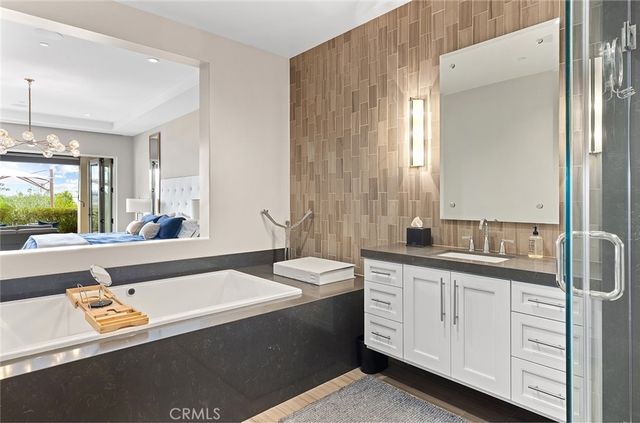 a spacious bathroom with a granite countertop sink a mirror and a bathtub