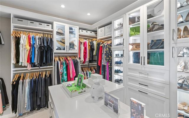 a view of walk in closet with clothes and shoes