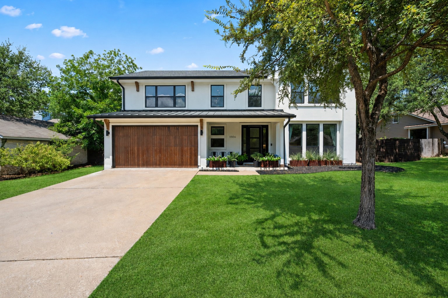 11506 Autumn Ridge Drive Austin, TX 78759 - Photo 1 of 23 A modern two-story residence with a striking dark wood garage door and custom metal planters offers inviting curb appeal.