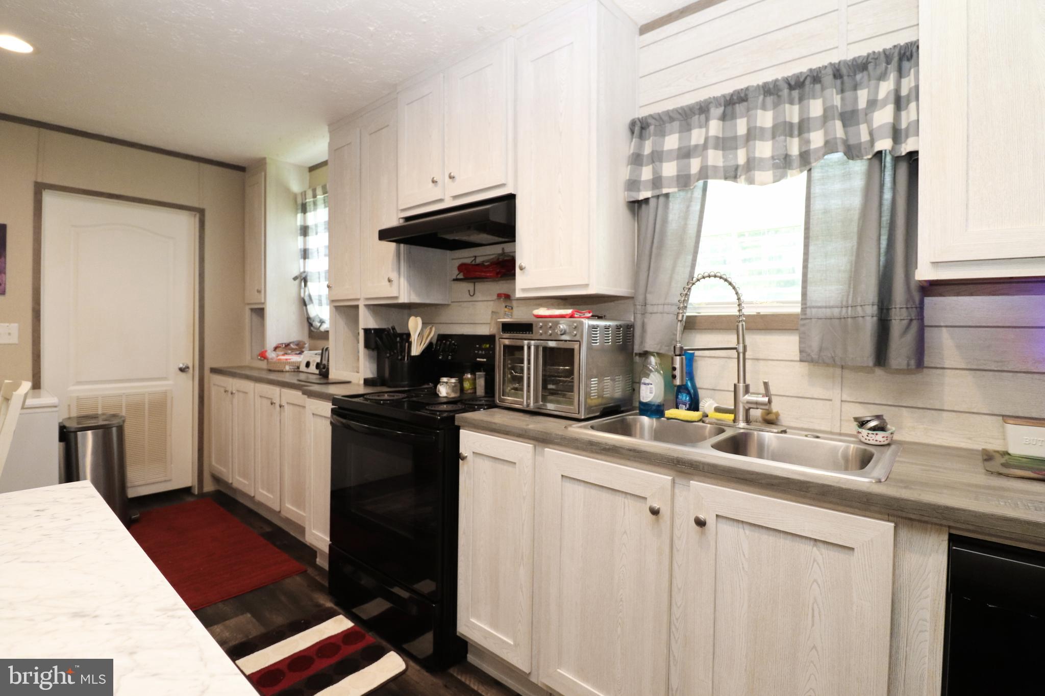 11276 Hodson White Road Deal Island, MD 21821 - Photo 11 of 27 a kitchen with a sink stove and cabinets