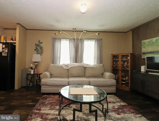 a living room with furniture a flat screen tv and a window