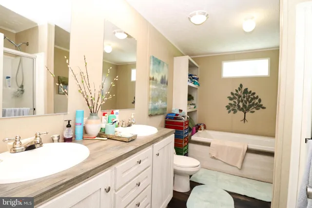 a bathroom with a granite countertop sink mirror vanity and toilet