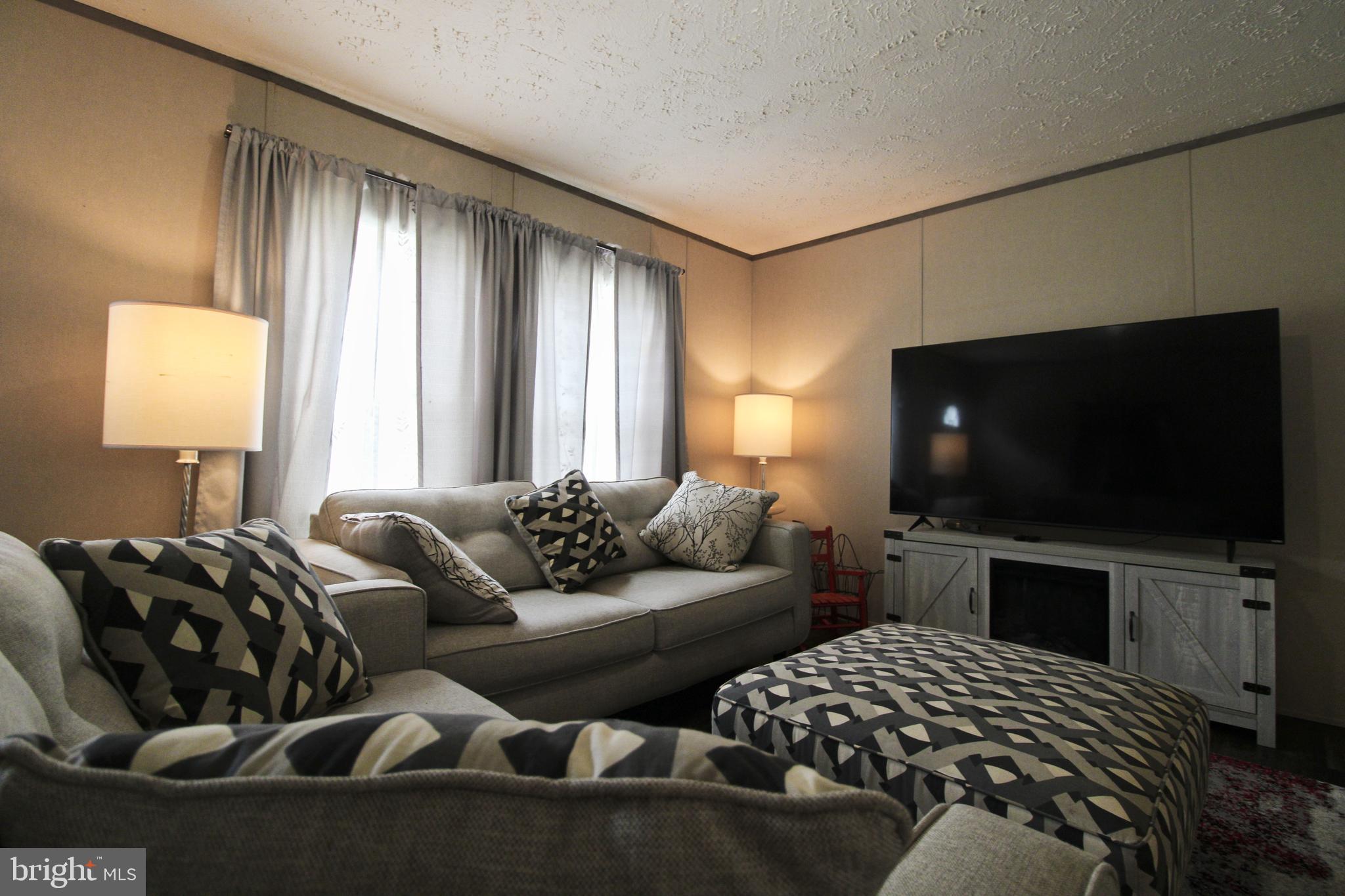 11276 Hodson White Road Deal Island, MD 21821 - Photo 4 of 27 a bedroom with furniture and a flat screen tv