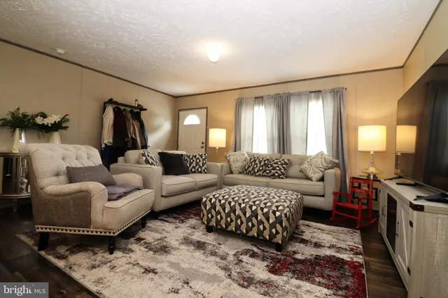 a living room with furniture a flat screen tv and a window