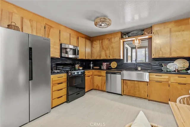a kitchen with stainless steel appliances a refrigerator sink and stove