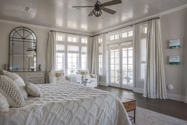 a spacious bedroom with a large bed and a chandelier