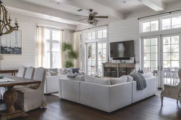 a living room with furniture a flat screen tv and a large window