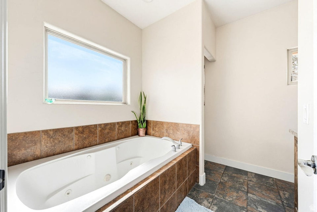 7776 Wagon Road East St. George, UT 84770 - Photo 26 of 76 Bathroom with stone tile floors and a tub with jets