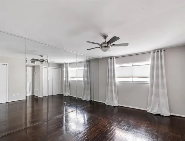 a view of empty room with wooden floor and window