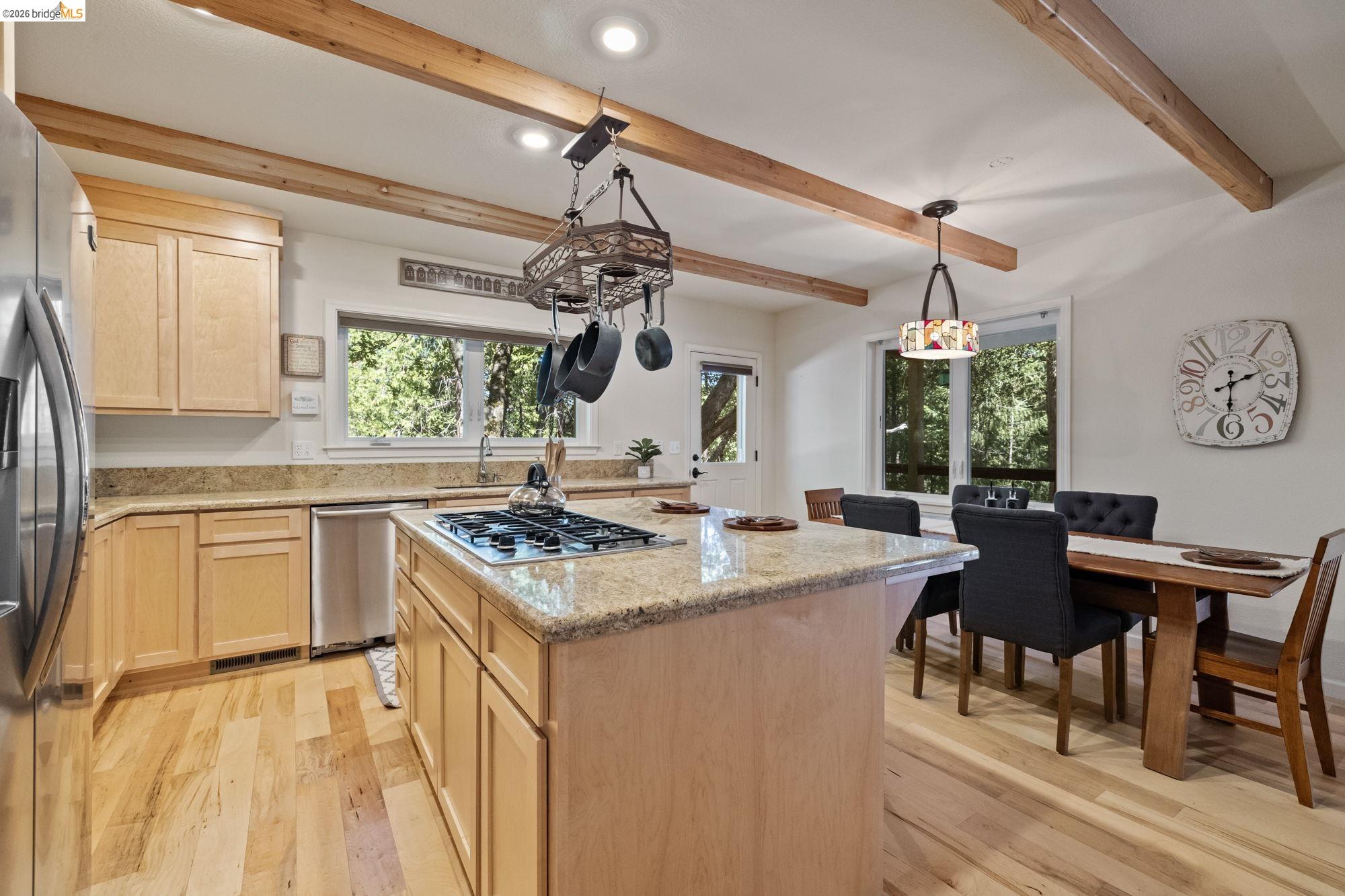 24669 Center Camp Road Twain Harte, CA 95383 - Photo 11 of 33 a kitchen with a stove a refrigerator a dining table and chairs with wooden floor