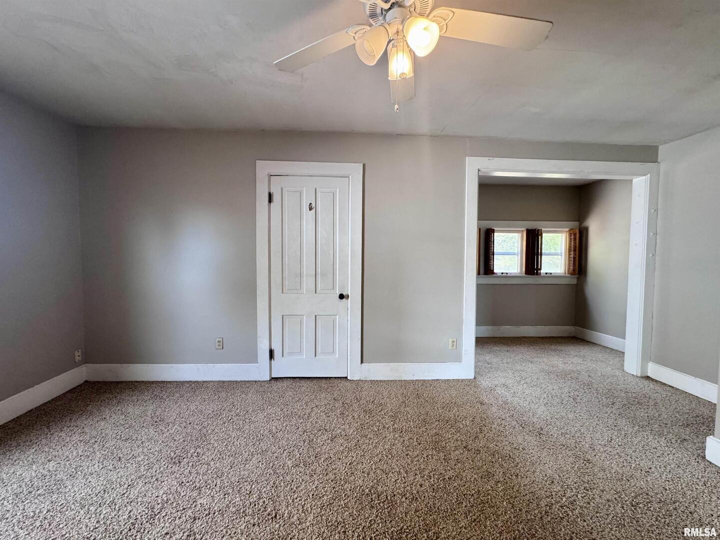 916 7th Street Fulton, IL 61252 - Photo 16 of 32 an empty room with a chandelier fan and windows