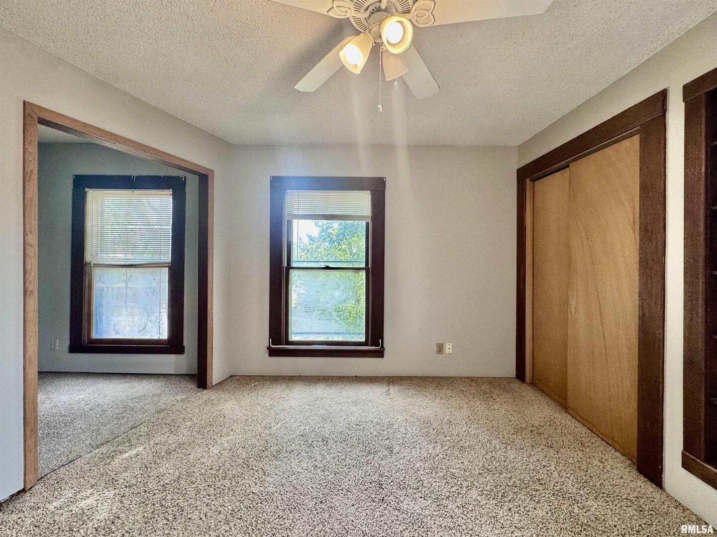 916 7th Street Fulton, IL 61252 - Photo 20 of 32 an empty room with windows and chandelier fan