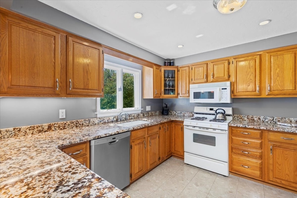 30 South Cross Road Haverhill, MA 01835 - Photo 12 of 42 a kitchen with stainless steel appliances granite countertop a stove sink and cabinets