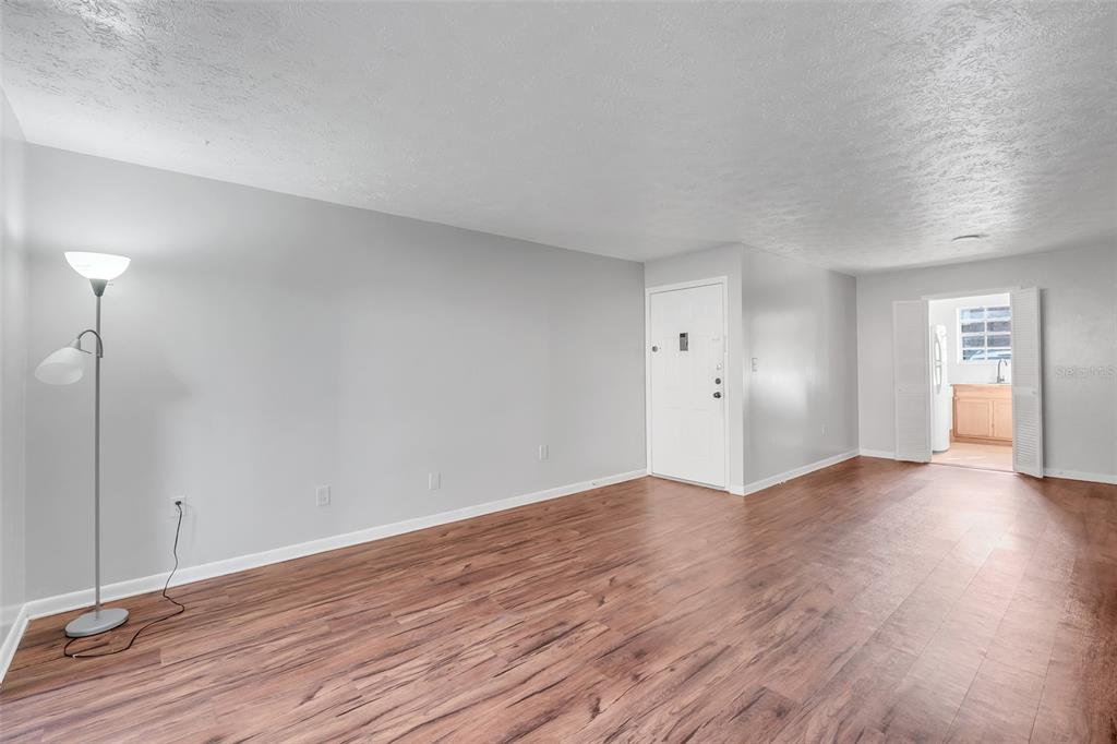 4212 Lake Underhill Road, Unit 5D9 Orlando, FL 32803 - Photo 3 of 58 a view of an empty room with window and wooden floor