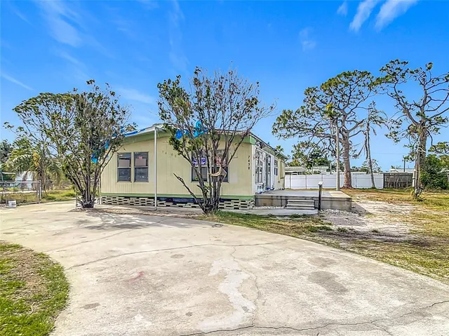 a view of a yard with a tree in front of it