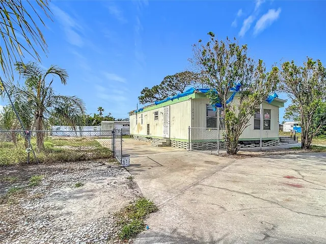 a row of palm trees in front of a house