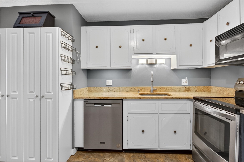 38 Bennett Street, Unit 3D Wakefield, MA 01880 - Photo 11 of 22 a kitchen with stainless steel appliances granite countertop a sink and a stove