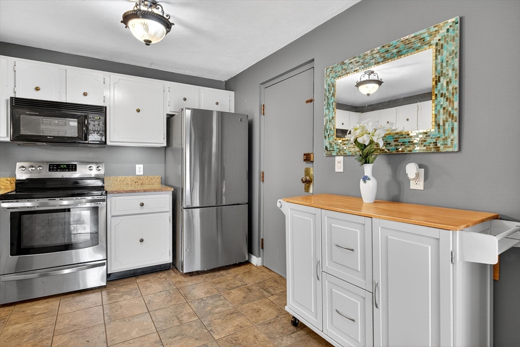 38 Bennett Street, Unit 3D Wakefield, MA 01880 - Photo 12 of 22 a kitchen with stainless steel appliances granite countertop a refrigerator sink and stove