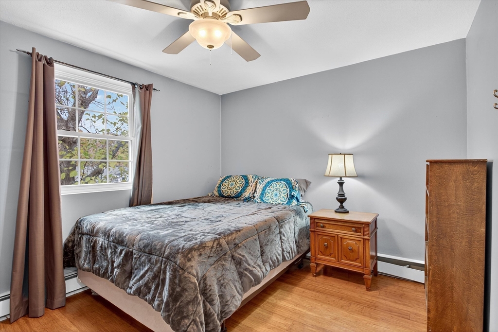38 Bennett Street, Unit 3D Wakefield, MA 01880 - Photo 16 of 22 a bedroom with a bed a chandelier and a window