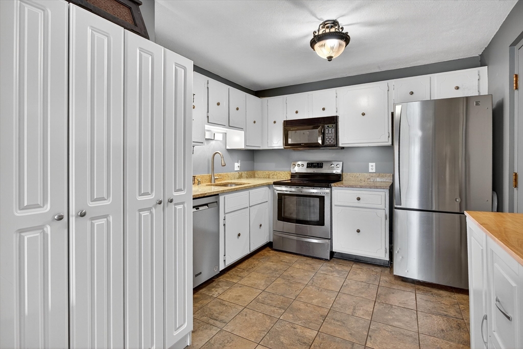 38 Bennett Street, Unit 3D Wakefield, MA 01880 - Photo 10 of 22 a kitchen with cabinets a refrigerator and a stove top oven