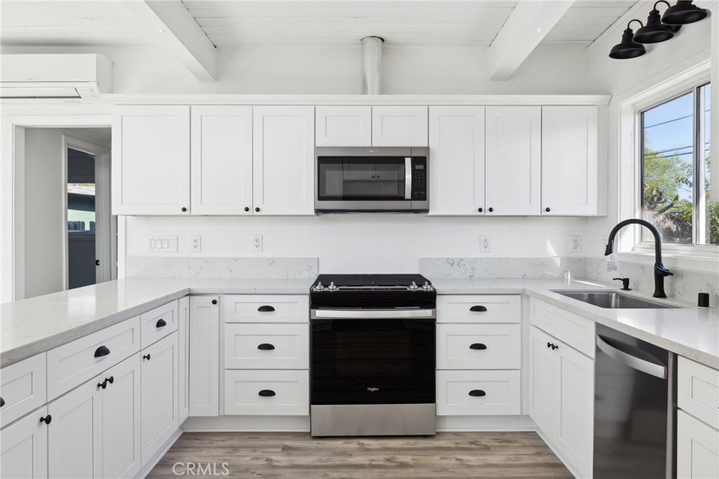 528 Creston Road Paso Robles, CA 93446 - Photo 25 of 46 a kitchen with white cabinets and black appliances