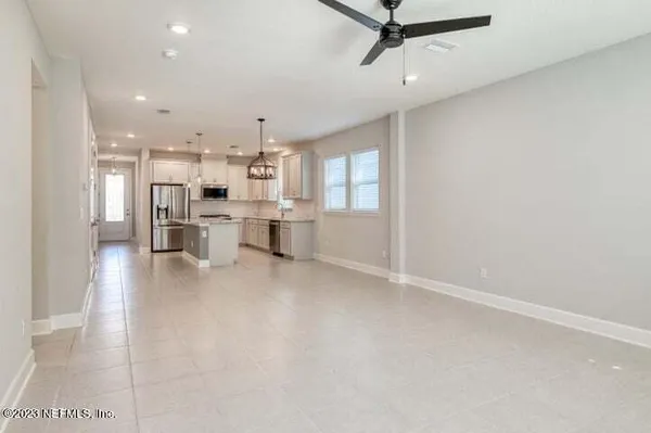a view of kitchen with stainless steel appliances a refrigerator a sink dishwasher with a dining table and chairs