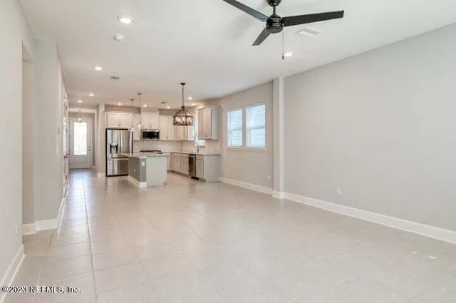 a view of kitchen with stainless steel appliances a refrigerator a sink dishwasher with a dining table and chairs
