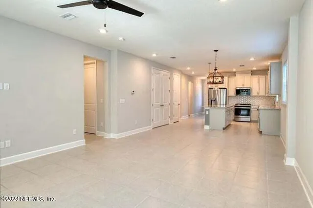 a view of a kitchen and an empty room
