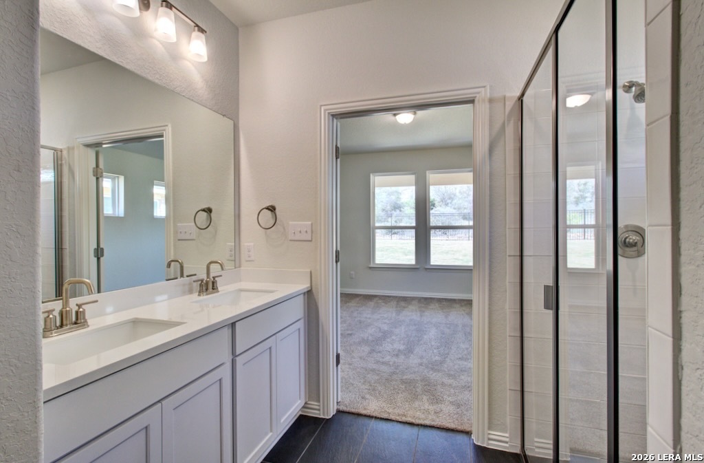 11234 Prairie Landing Converse, TX 78109 - Photo 6 of 6 a bathroom with a double vanity sink and mirror with shower