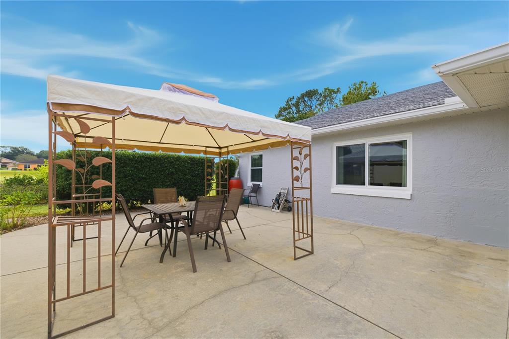 9049 Southwest 91st Circle Ocala, FL 34481 - Photo 32 of 37 a patio with a table and chairs and potted plants