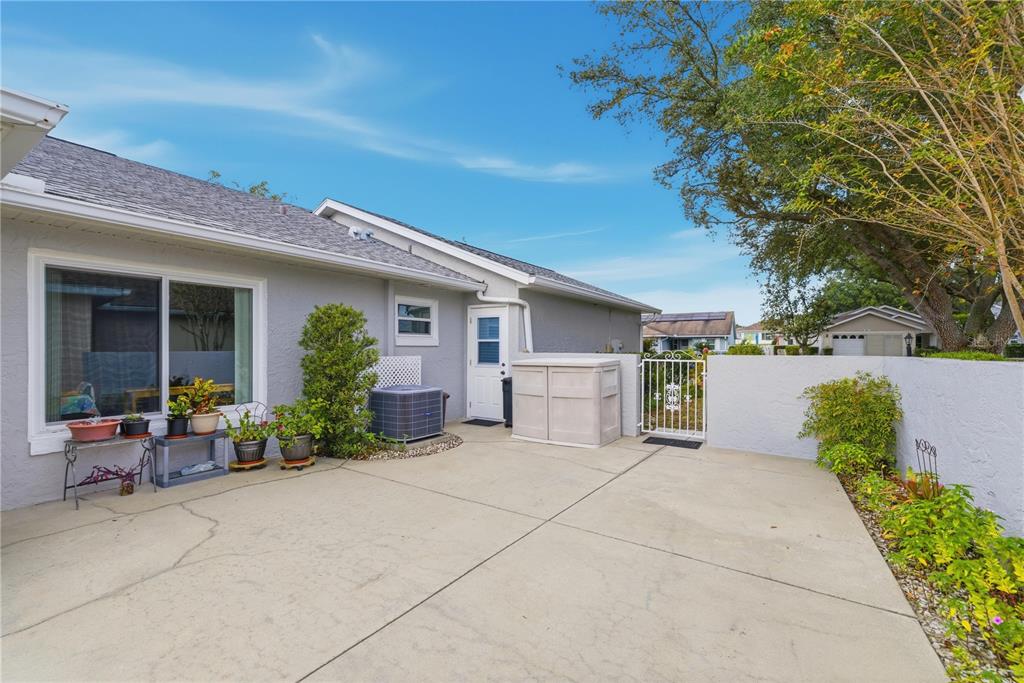 9049 Southwest 91st Circle Ocala, FL 34481 - Photo 33 of 37 a view of a patio with table and chairs potted plants and a large tree