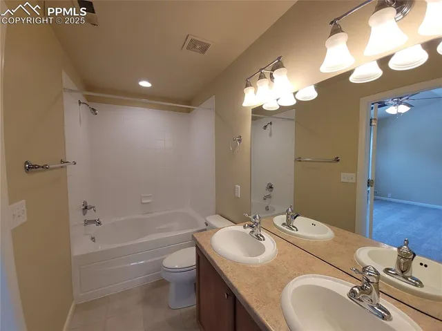 a bathroom with a granite countertop sink a toilet and shower