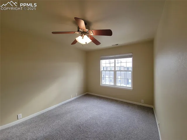 a view of a room with windows and ceiling fan