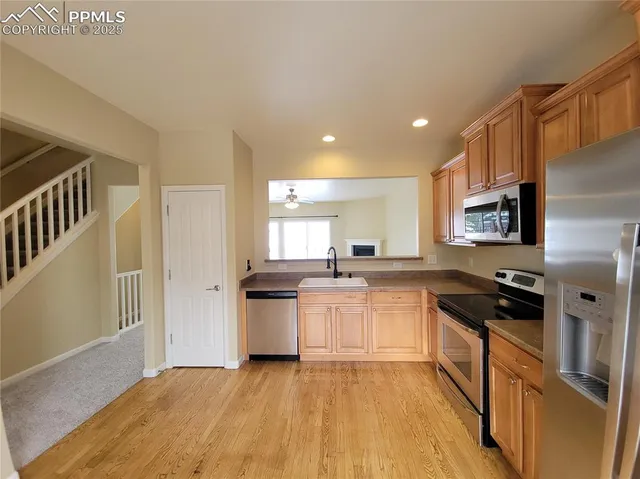 a kitchen with granite countertop a refrigerator stove top oven and sink