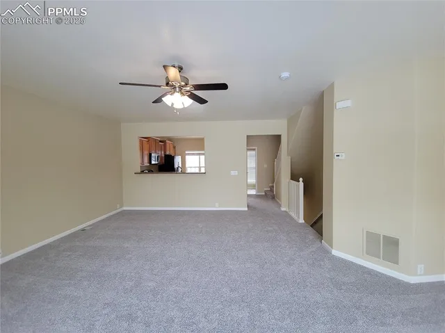 a view of a room with a ceiling fan and a window