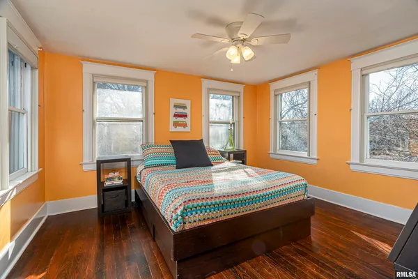 a bedroom with a bed wooden floor and window