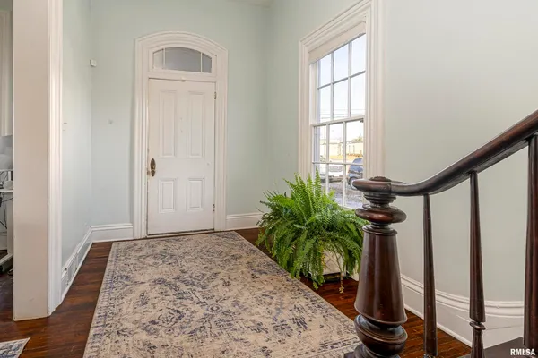 a view of a hallway with wooden floor and a potted plant