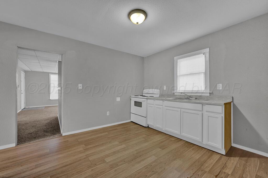 4006 Southeast 13th Avenue Amarillo, TX 79104 - Photo 6 of 16 a kitchen with granite countertop white cabinets and white appliances