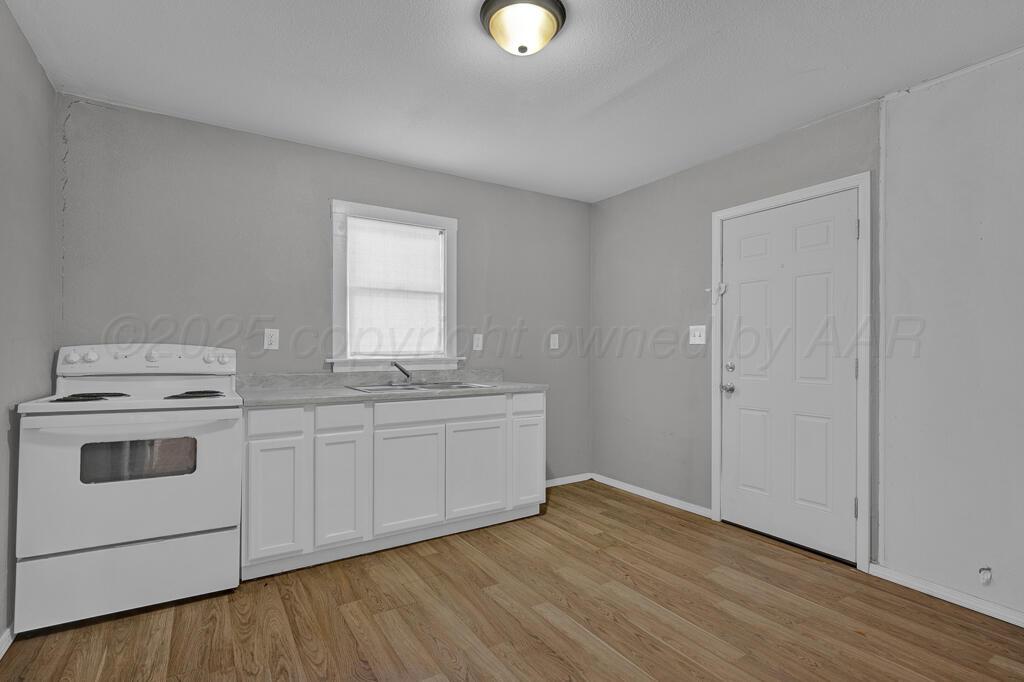 4006 Southeast 13th Avenue Amarillo, TX 79104 - Photo 7 of 16 a view of a kitchen with a sink cabinets and wooden floor