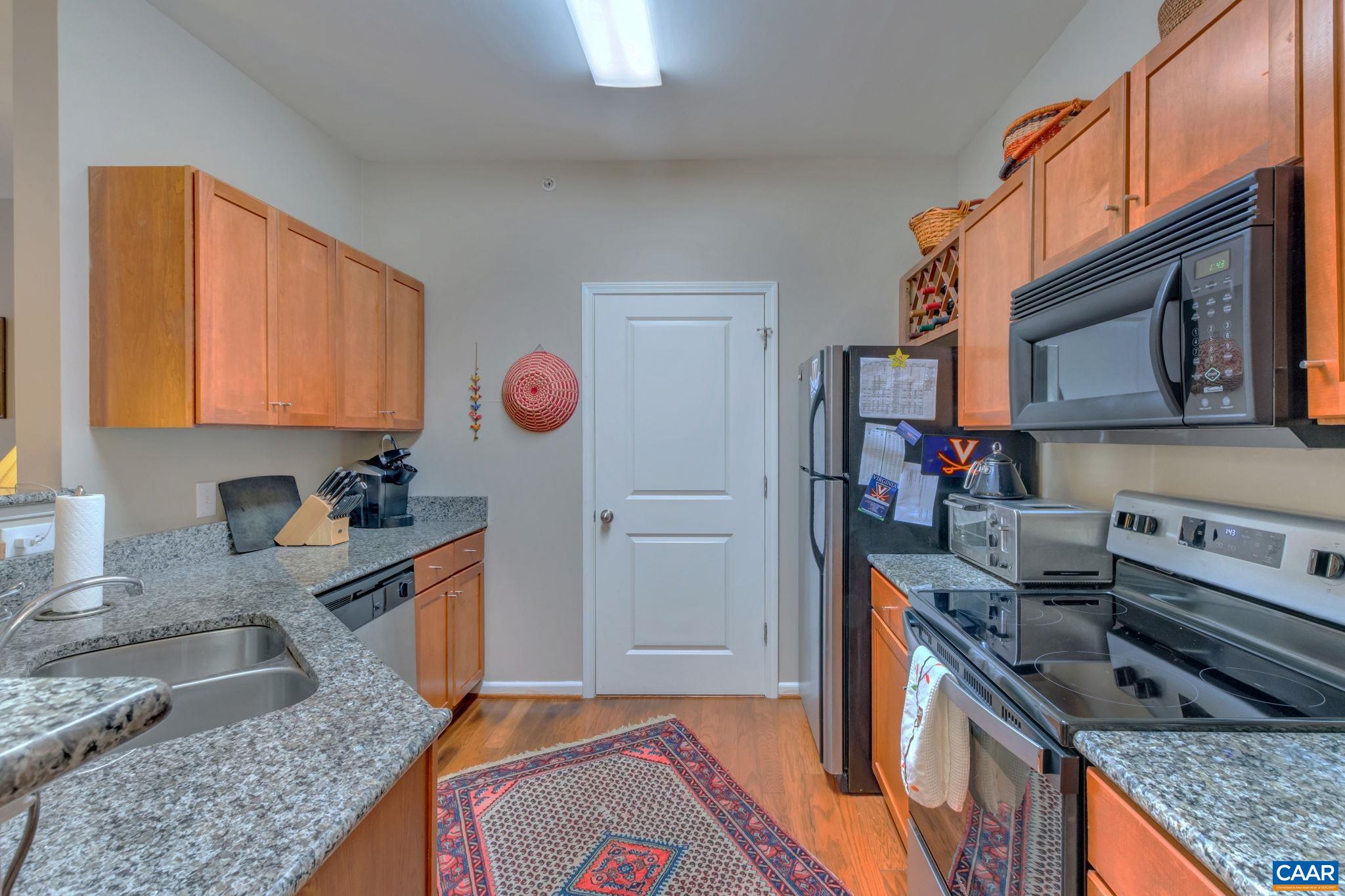 765 Walker Square, Unit 2D Charlottesville, VA 22903 - Photo 6 of 33 a kitchen with stainless steel appliances granite countertop a sink stove and refrigerator