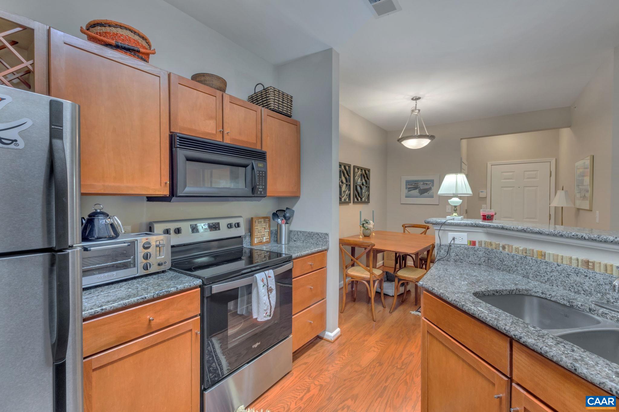 765 Walker Square, Unit 2D Charlottesville, VA 22903 - Photo 8 of 33 a kitchen with stainless steel appliances granite countertop a sink stove and refrigerator