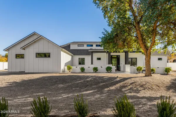 a view of a dining room and livingroom with furniture wooden floor a rug a fireplace and a chandelier