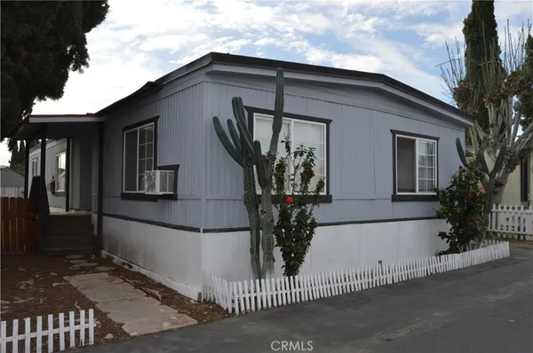 a view of a house with a small yard and potted plants