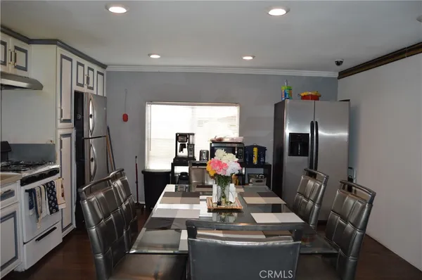 a kitchen with stainless steel appliances dining table and chairs