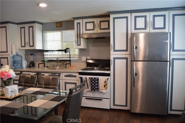 a kitchen with stainless steel appliances granite countertop a refrigerator sink and stove